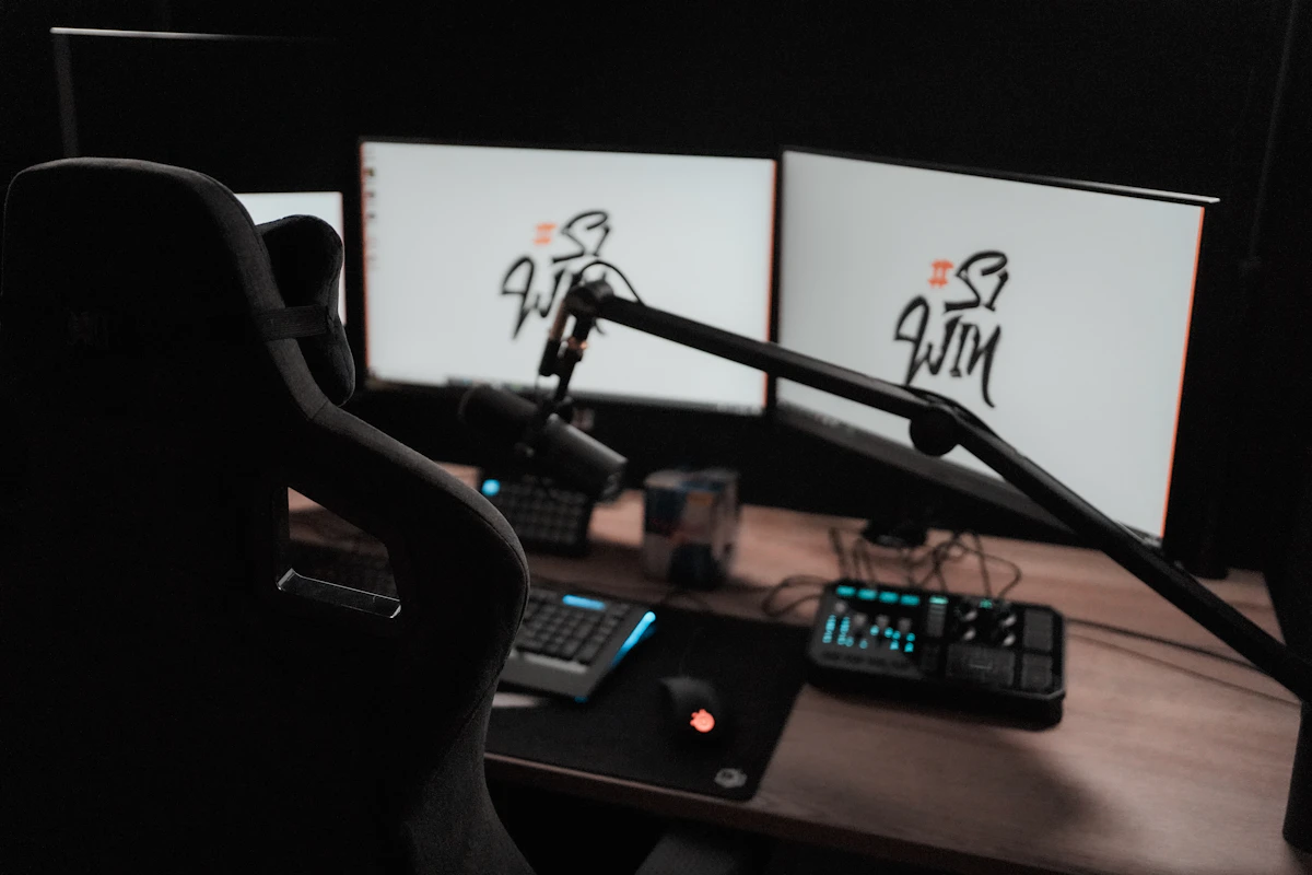 Meja komputer dengan dua monitor dan mikrofon untuk live streaming